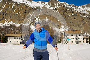 Lifestyle portrait of young happy and attractive man doing cross country ski enjoying winter holidays on Swiss Alps having fun on