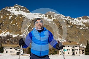 Lifestyle portrait of young happy and attractive man doing cross country ski enjoying winter holidays on Swiss Alps having fun on