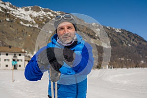 Lifestyle portrait of young happy and attractive man doing cross country ski enjoying winter holidays on Swiss Alps having fun on