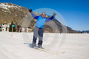 Lifestyle portrait of young happy and attractive man doing cross country ski enjoying winter holidays on Swiss Alps having fun on