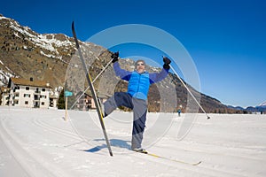 Lifestyle portrait of young happy and attractive man doing cross country ski enjoying winter holidays on Swiss Alps having fun on