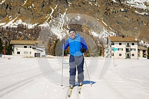 Lifestyle portrait of young happy and attractive man doing cross country ski enjoying winter holidays on Swiss Alps having fun on