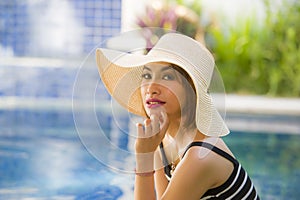 Lifestyle portrait of young happy and beautiful tourist woman in Summer hat posing relaxed and smiling cheerful at tropical resort