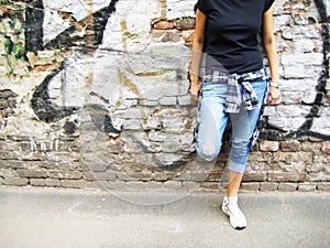 Lifestyle portrait of young person against colorful urban brick wall background