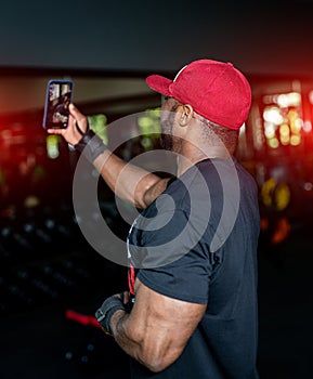 Lifestyle strong bodybuilder with athlete torso. Muscular handsome afro man in the gym.