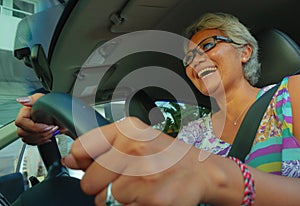 Lifestyle Summer portrait of middle aged happy and attractive classy Asian Indonesian woman driving car smiling cheerful and free