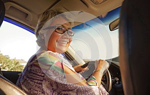 Lifestyle Summer portrait of middle aged happy and attractive classy Asian Indonesian woman driving car smiling cheerful and free