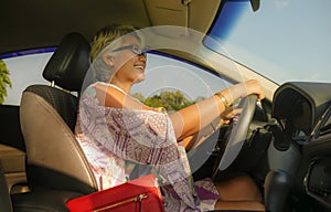 Lifestyle Summer portrait of middle aged happy and attractive classy Asian Indonesian woman driving car smiling cheerful and free