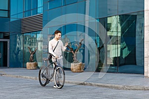 Lifestyle, transport, communication and people. Young man with bicycle and smartphone