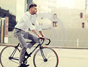 Man with headphones riding bicycle on city street