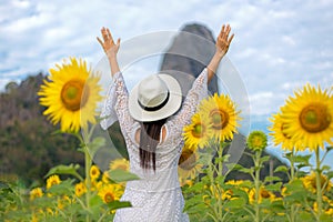 Lifestyle traveler or tourism women happy feeling good relax and freedom facing on the natural sunflower farm outdoors in the sunr