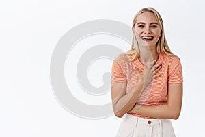 Lifestyle, wellbeing and happiness. Attractive stylish blond caucasian girl in striped t-shirt laughing as casually