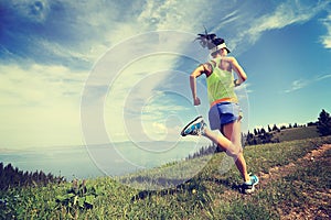 Lifestyle woman trail runner running on mountain peak