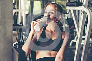 Lifestyle women drinking protein milk after exercise  at the gym workout for healthy care and body slim.  Fitness instructor exerc