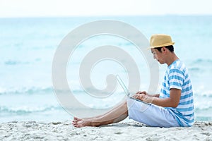 Lifestyle young asian man working on laptop while sitting chill