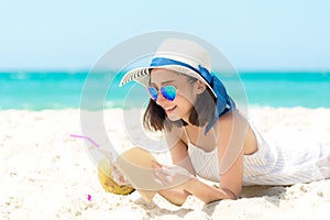 Lifestyle young  woman relax on the summer beach.  Asia tourism people reading and chill in holiday. blue sky background.