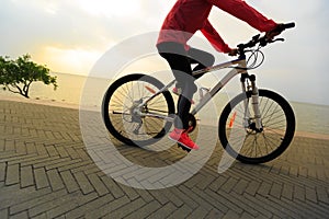 Lifestyle young woman riding bike on seaside