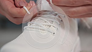 lifestyle, young woman tying shoelaces on sports white lace-up shoes, movement and life concept, close-up