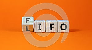 LIFO or FIFO last in first out symbol. Changed concept words LIFO to FIFO on wooden blocks. Beautiful orange table orange