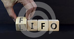 LIFO or FIFO last in first out symbol. Changes concept words LIFO to FIFO on wooden blocks. Beautiful grey table grey background.