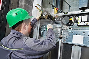 Lift machinist adjusting elevator mechanism