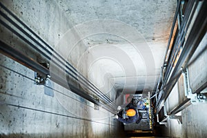 Lift machinist repairing elevator in lift shaft