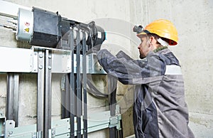 Lift machinist repairing elevator in lift shaft