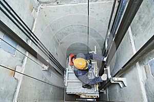 Lift machinist repairing elevator in lift shaft