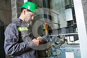 Lift machinist repairing elevator in lift shaft