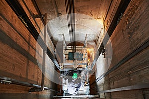 Lift machinist repairing elevator in lift shaft photo