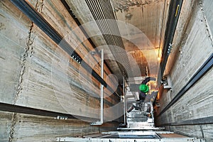 Lift machinist repairing elevator in lift shaft photo