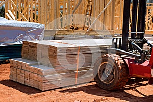 Lift manipulator unloads wooden delivered building material on construction site