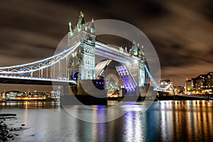 The lifted Tower Bridge in London, UK, by night