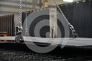 Lifting chains and hooks for loading sheet metal.