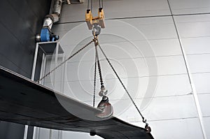 Lifting chains and hooks for loading sheet metal. Grab