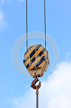 Lifting hook attached to sheave suspended by wire rope from boom of crane