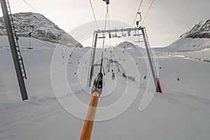 Lifting on the ski drag lift rope over sunlight near mountain peak