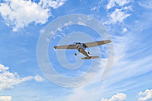 Light aircraft flying over blue sky