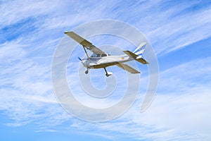 Light aircraft flying over blue sky