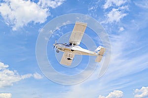 Light aircraft flying over blue sky
