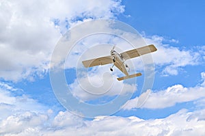 Light aircraft flying over blue sky