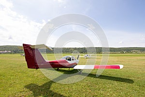 Light aircraft parked on the grass next to a small airport