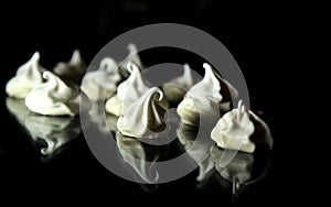 Light and airy meringue lies on a glass table reflected in a dark dining room