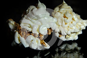 Light and airy meringue lies on a glass table reflected in a dark dining room