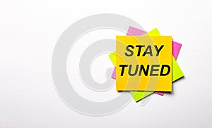 On a light background - bright multicolored stickers with the text STAY TUNED. Copy space photo