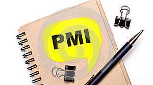 On a light background, a brown notebook, a black pen and paper clips, and a yellow card with the text PMI Project Management