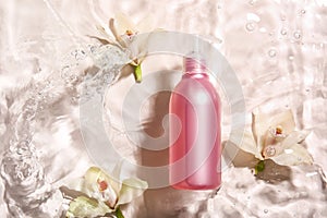 Bottle of cosmetic product and flowers in water on light background