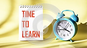 On a light background on a notebook, the text TIME TO LEARN