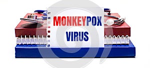 On a light background notepad, a stethoscope and a white card with the text MONKEYPOX VIRUS. Medical concept photo