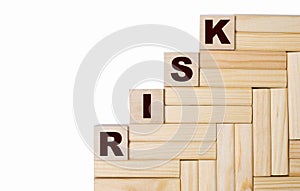 On a light background, wooden blocks and cubes with the text RISK